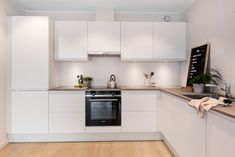 a kitchen with white cabinets and wood flooring is pictured in this image from the front view