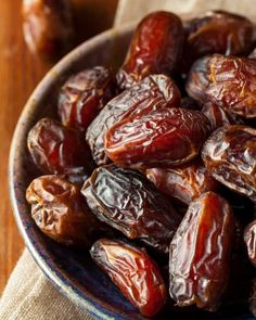 a bowl filled with raisins on top of a wooden table