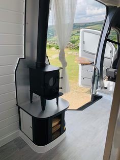 the interior of a small camper with a stove in it's back door