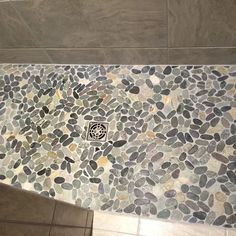 a tile floor with pebbles on it in a bathroom