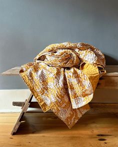 a blanket on top of a wooden bench