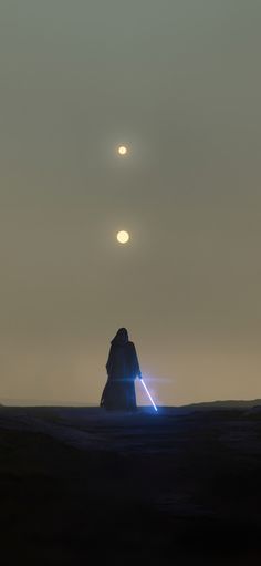 two people standing in the desert at night with their lights on and one person holding a light saber