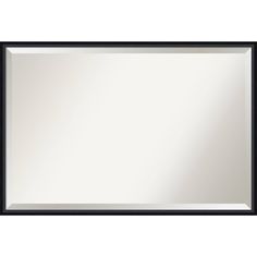 a large black framed mirror on a white wall with an empty space in the middle