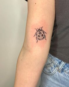 a ladybug tattoo on the left arm