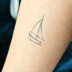 a small sailboat tattoo on the arm