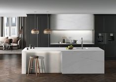 a modern kitchen with marble counter tops and dark wood flooring, along with an island in the middle