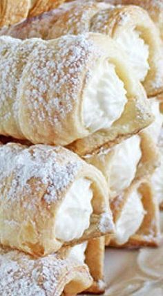 several pastries piled on top of each other with powdered sugar in the middle