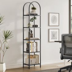 a black metal book shelf with books and plants on it next to a chair in front of a window