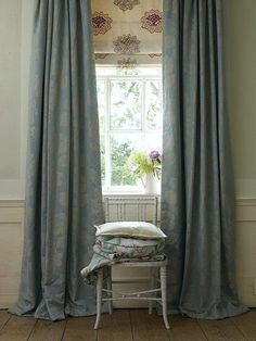 a chair sitting in front of a window with curtains