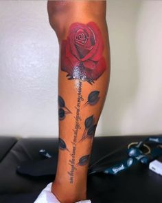 a woman's leg with a rose tattoo on it and some words written in black ink