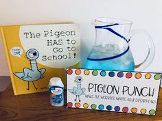 a wooden table topped with books and glasses filled with blue liquid next to a sign