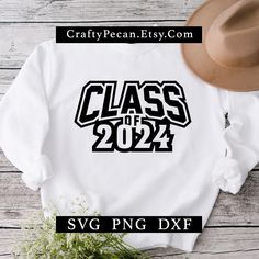 a white sweatshirt with the class of 2021 on it and a hat next to it