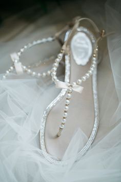 a pair of white shoes with pearls on them