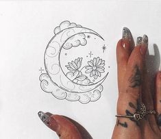 a person's hand with tattoos on it next to a drawing of a crescent moon