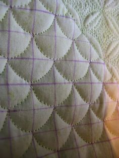 close up view of the stitchs on a quilted material with white and purple lines