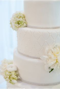 a white wedding cake with flowers on top