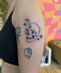 a woman's arm with a skull and stars tattoo on the left side of her body