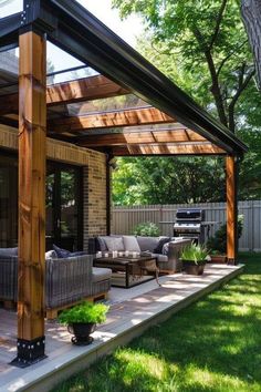 a covered patio with couches and tables in the grass next to a fenced in area