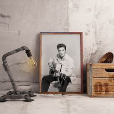 a black and white photo sitting on top of a wooden box next to a lamp