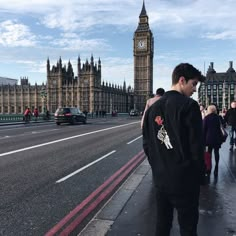 a man standing on the sidewalk in front of big ben