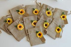 small bags with sunflowers are tied to burlocks on a white table