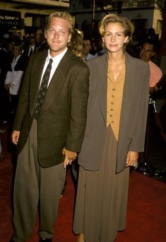 a man and woman standing next to each other on a red carpet at an event