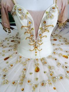 a white dress with gold beads on it