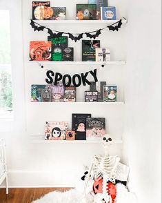 a halloween themed room with bookshelves and decorations on the wall, including a spook sign