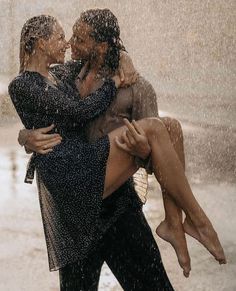 two people hugging each other in the rain