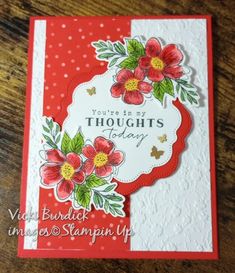 a red and white card with flowers on it