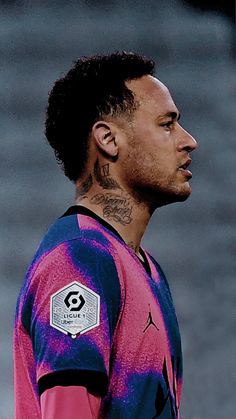 a man with tattoos on his neck and chest standing in front of a soccer ball