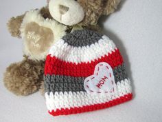 a teddy bear is next to a knitted hat