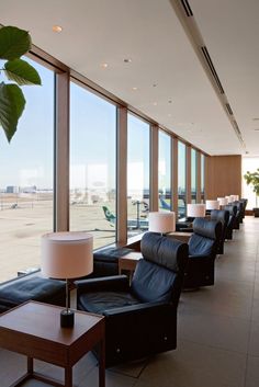 an airport lounge area with large windows looking out onto the tarmac