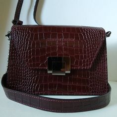 New Maroon Shoulder/ Crossbody Designer Purse. Front Flap. Magnetic Closure. Front Logo. Faux Crocodile Pattern Exterior Finish. Leather/ Chain 10" Drop Shoulder Strap. Adjustable 46" Crossbody Strap. Bifold Construction. Interior Zipper Pocket. Gun Metal Hardware. Zippered Storage Pouch. Aprox. Dimensions: 9"X 6" X 4". Authenticity Certificate Card. Made In Italy. Textured Leather Burgundy Bag For Office, Burgundy Textured Leather Bag For Office, Burgundy Textured Leather Bag For Evening, Burgundy Textured Leather Evening Bag, Burgundy Textured Leather Office Bag, Formal Textured Leather Burgundy Bag, Burgundy Bag With Magnetic Closure For Everyday Use, Burgundy Textured Leather Crossbody Shoulder Bag, Authenticity Certificate