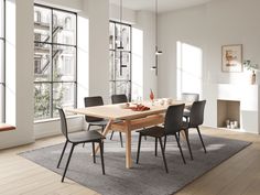 a dining room table and chairs in front of large windows with lots of natural light