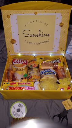 an open yellow box filled with snacks and condiments on top of a table