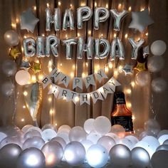 a happy birthday banner with balloons and confetti in front of a backdrop that says happy birthday