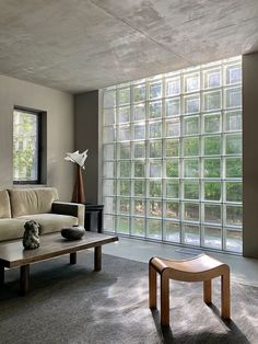 a living room filled with furniture next to a window covered in glass block wall panels