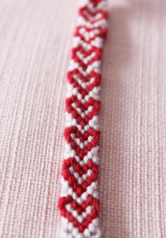 a red and white beaded bracelet sitting on top of a table