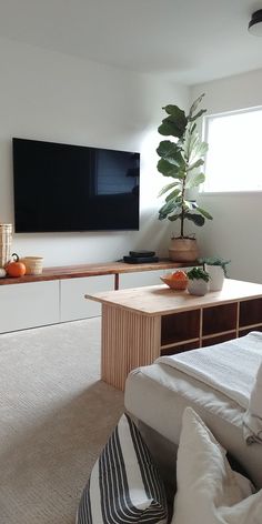 a large flat screen tv mounted to the side of a wall in a living room