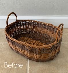 a wicker basket sitting on the floor next to a white wall and tile floor