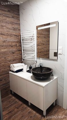 a bathroom with a sink, mirror and towel rack