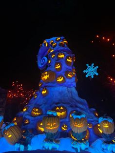 pumpkins carved into the shape of a tower at night