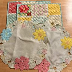 three placemats with flowers on them sitting on a table