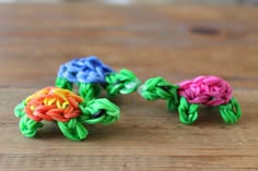 there are three small pieces of colorful yarn on the table together, one is made from plastic beads