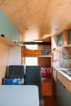 the interior of a small camper with bunk beds and desks in place for people to use