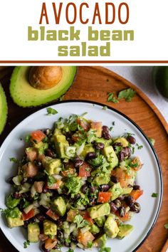 avocado black bean salad on a white plate with an avocado in the background