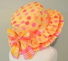 a mannequin wearing a yellow and pink polka dot hat