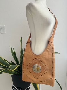 Gorgeous, hand tooled, leather handbag with etched metal concho. Bag is fully lined and has one zippered pocket and a zipper closure on the top.  In overall great vintage condition no notable flaws. No artisan stamp or label. Dimensions Height 11-17in/28-43cm Across 12.75in/32.5cm Width 1in/2.5cm    *Please keep in mind that unless otherwise noted, all items in my shop are used or previously owned, normal wear and tear is expected, flaws that are noted are range from major to minor, things like a missing stitch here or there my not be included. *Please read all policies on this and our policy page prior to making your purchase. *Please feel free to message me with any questions you may have as returns are not accepted. Response time is typically same day. **Attention International Buyers T Vintage Leather-backed Hobo Bag For Travel, Vintage Leather-backed Hobo Satchel Bag, Vintage Hobo Bag With Leather Backing For Travel, Vintage Leather Hobo Bag For Travel, Vintage Travel Hobo Bag With Leather Backing, Hand Tooled Vintage Brown Travel Shoulder Bag, Vintage Brown Hand-tooled Travel Shoulder Bag, Vintage Brown Hand Tooled Bag For Travel, Vintage Hobo Tote Bag With Leather Lining