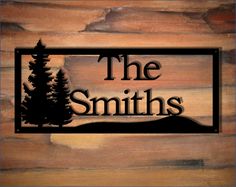 the smiths logo on a wooden wall with pine trees and mountains in the background